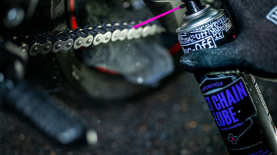 Muc-Off Wet Weather Chain Lube sprayed onto a motorcycle chain