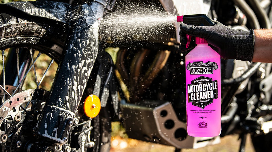Muc-Off Motorcycle Cleaner 1L sprayed onto a motorcycle wheel and fork