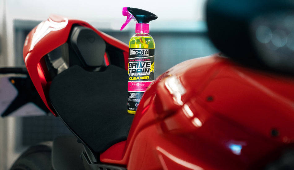 Muc-Off Powersports Drivetrain Cleaner 500ml beside a motorcycle