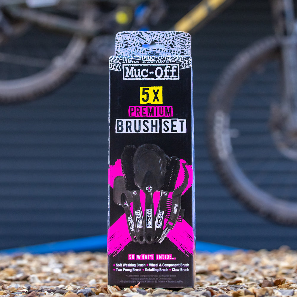 Muc-Off 5X Premium Brush Kit 206 packaged beside a bicycle