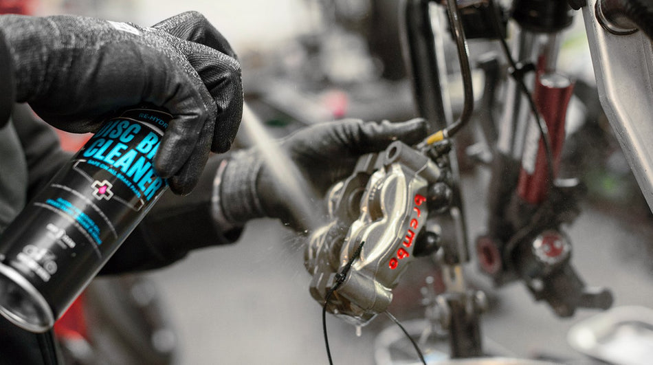Muc-Off Motorcycle Disc Brake Cleaner applied to a brake caliper